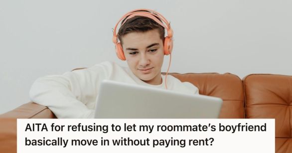 Man on couch with headphones on, looking at his computer