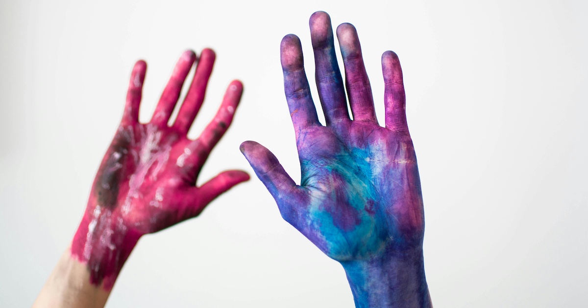 Two hands covered in paint
