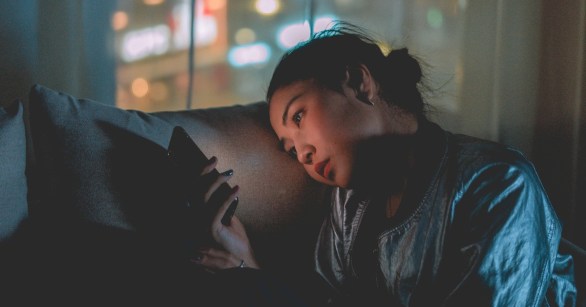 A woman using her phone at night