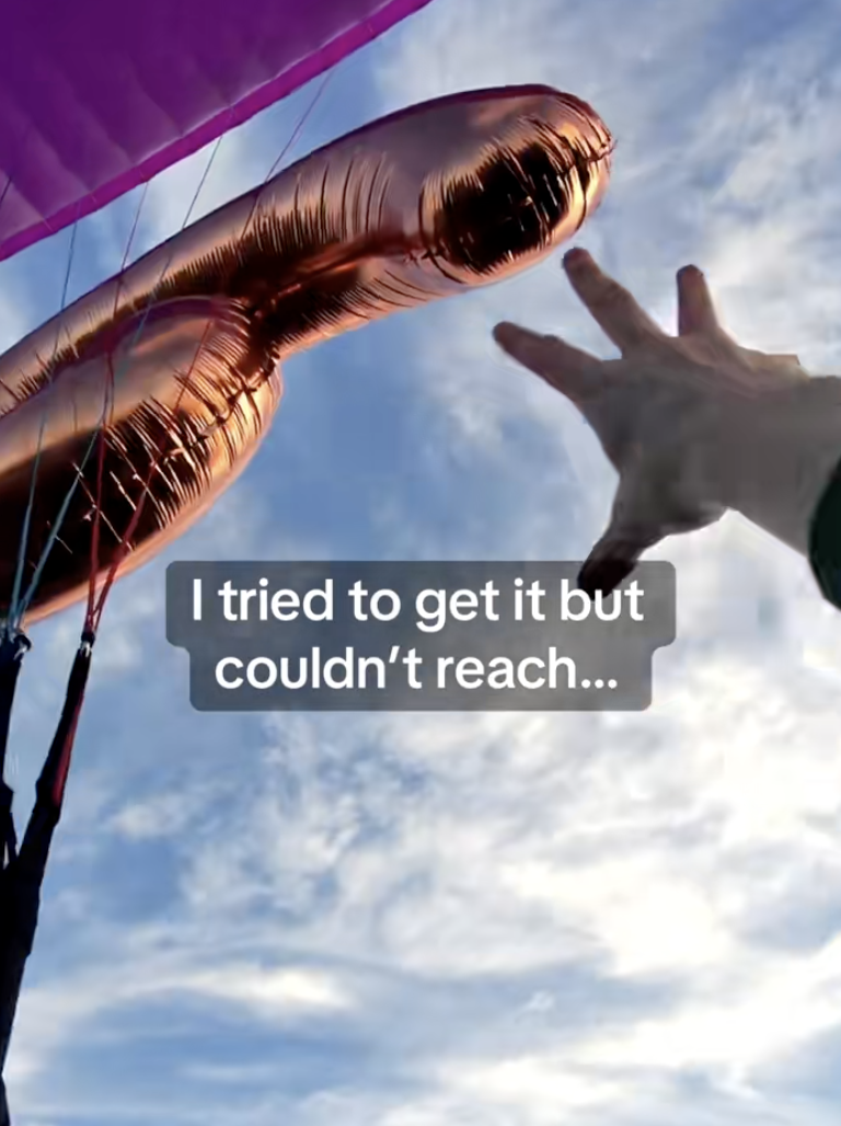 man reaching for a balloon
