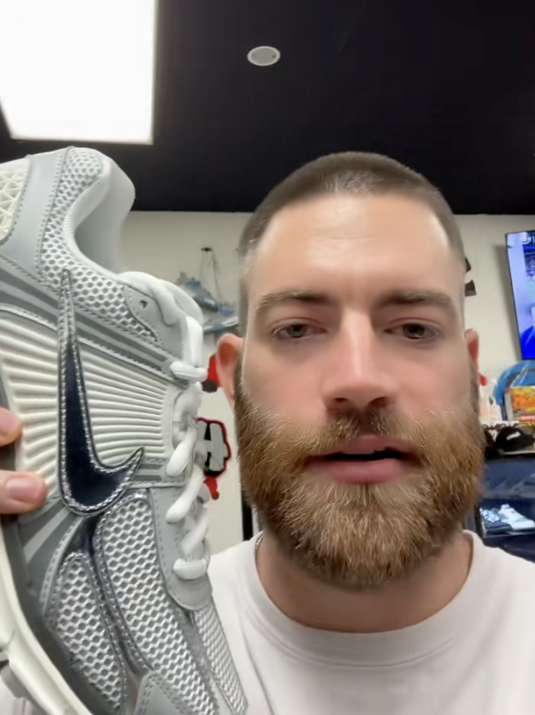 man holding up a sneaker