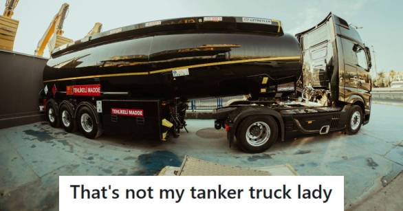 Black tanker truck parked outside of a gas station