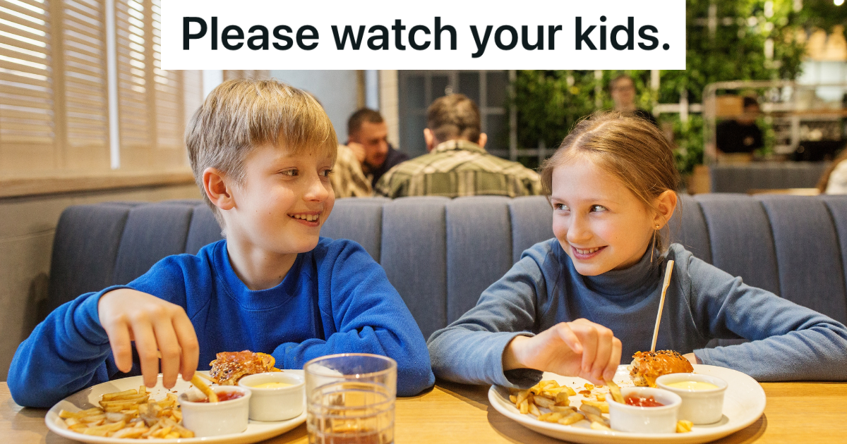 brother and sister smiling at each other in a restaurant