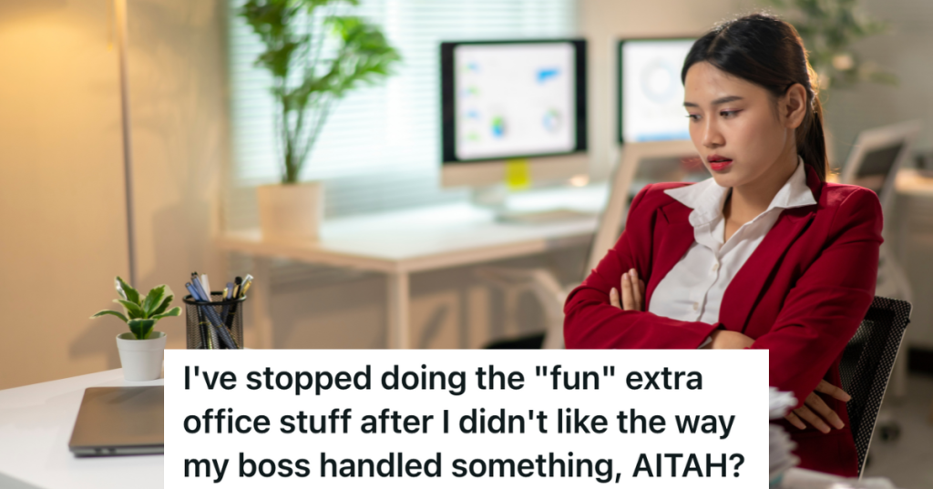 sad woman in a red jacket sitting at her desk at work