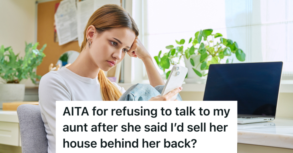 young woman sitting at her desk looking at her phone