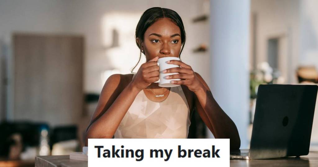 Woman sitting at her desk, taking a break and drinking some coffee