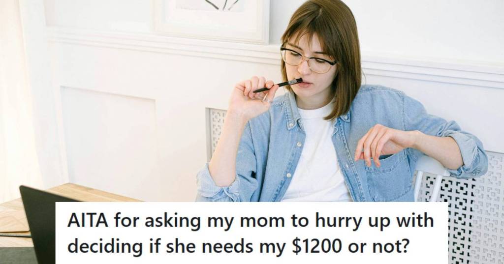 Young woman sitting at her computer with a notebook calculating finances