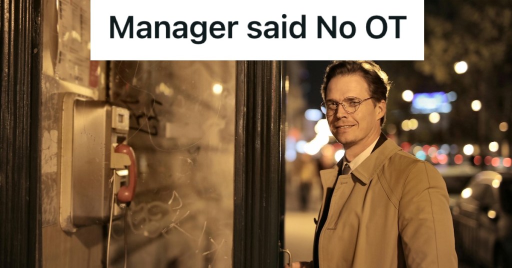 Man smiling next to a payphone