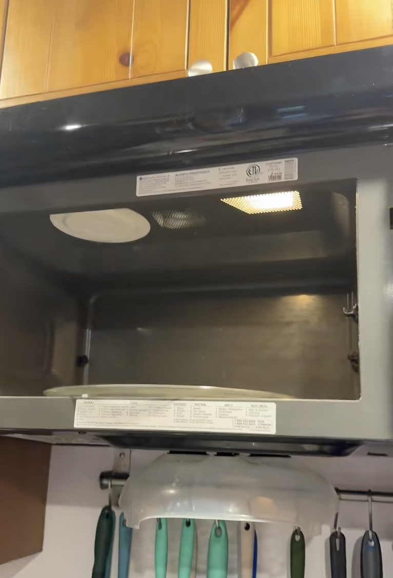 man looking at a microwave