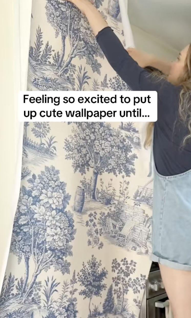 woman hanging up wallpaper