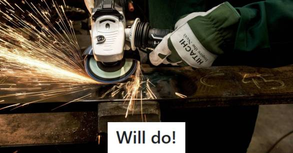 Man wearing gloves and using a saw to cut through steel