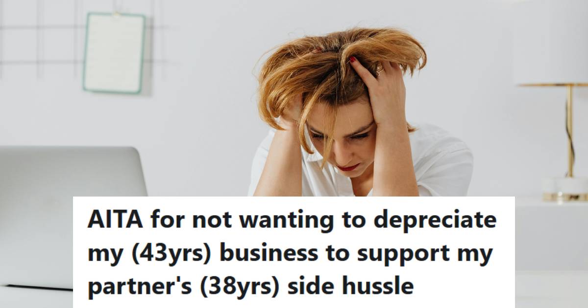 Woman sitting at a table, stressed and holding her head