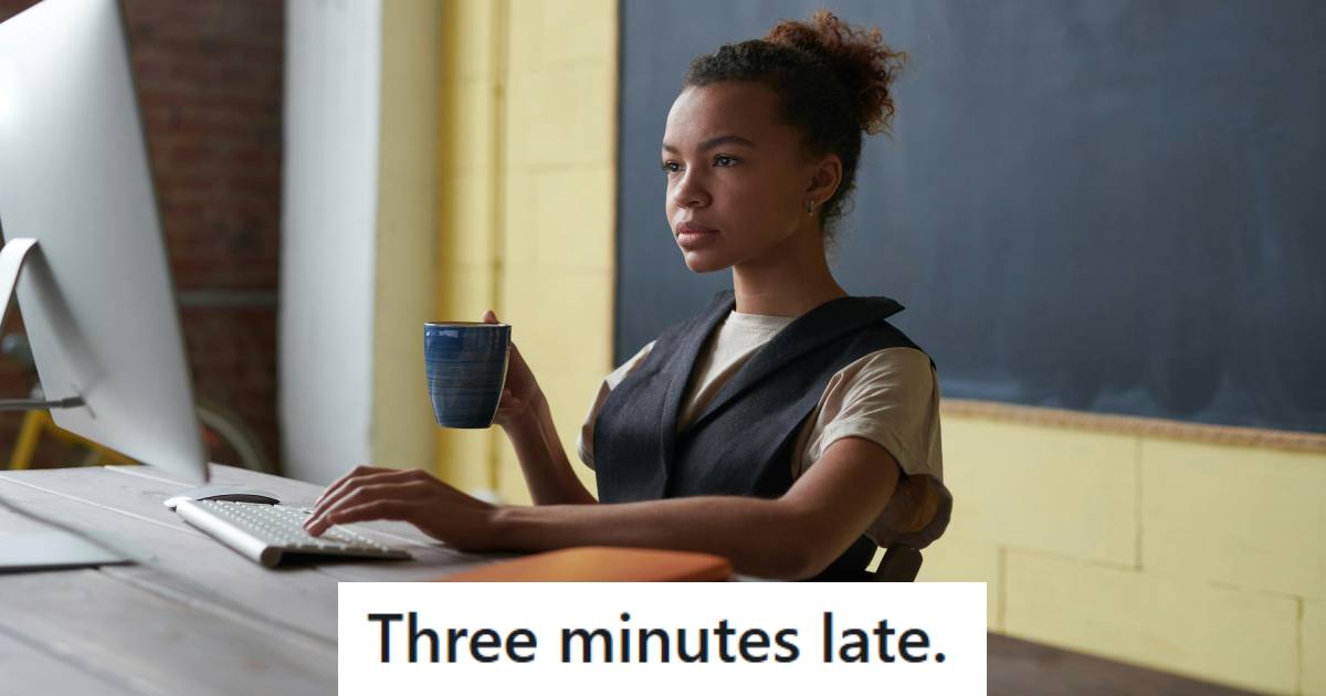 Teacher sitting at her desk starting work and drinking coffee