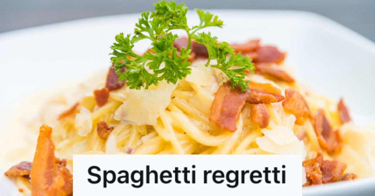 A bowl of carbonara pasta with bacon bits and parsley leaves