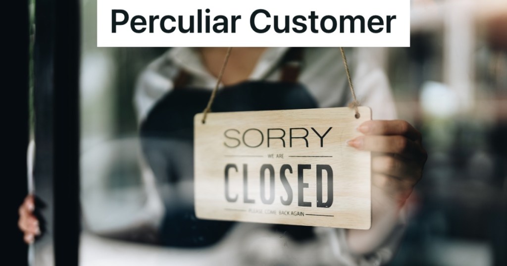 employee putting closed sign in store window