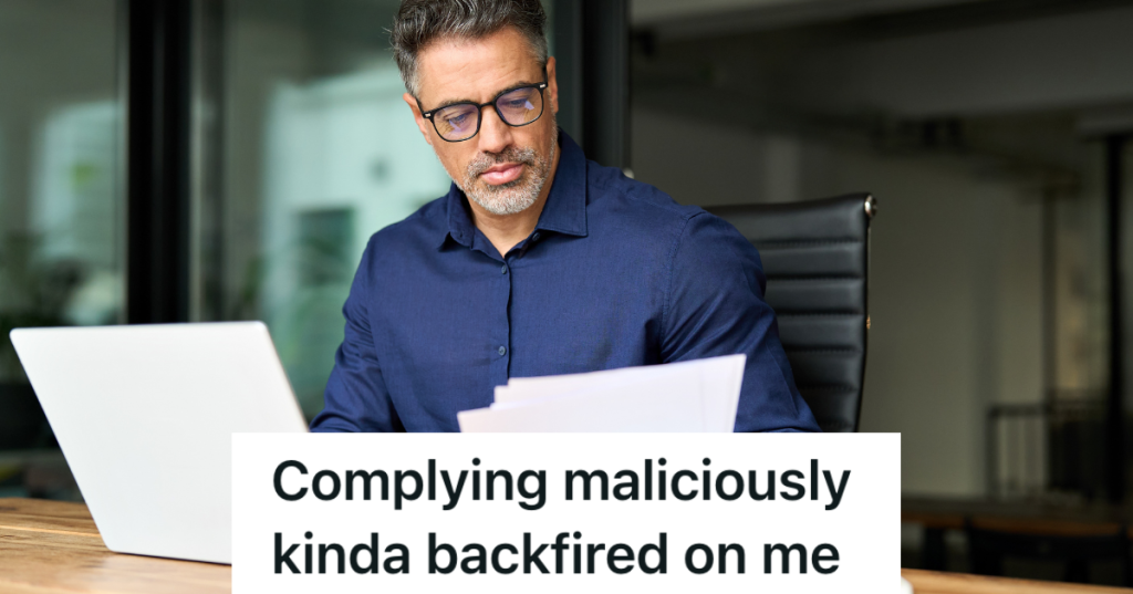 middle aged man in glasses looking at computer and paperwork
