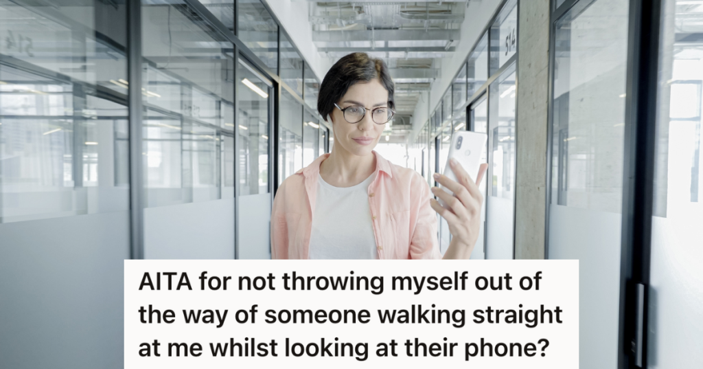 woman walking down a a hallways looking at her phone