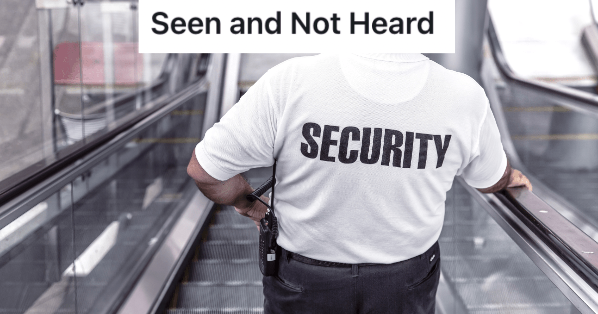 Back of man with shirt that says "security" riding down an escalator. 