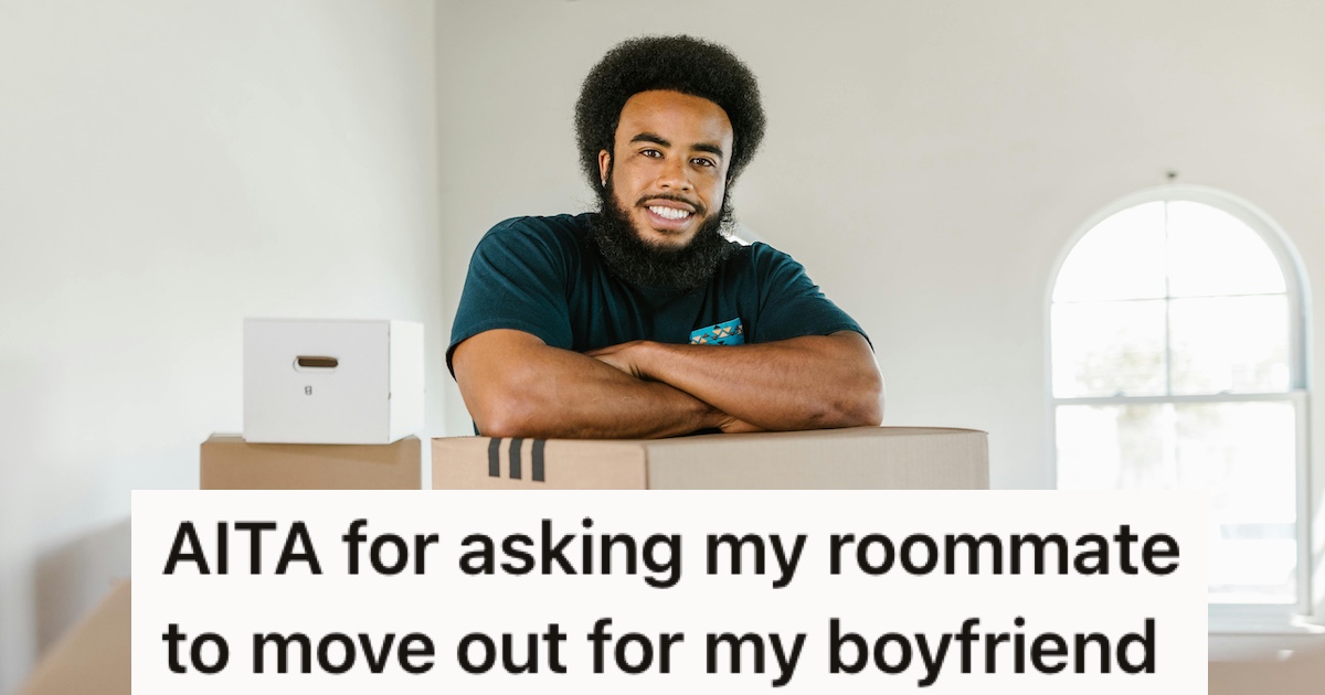 A smiling man leaning on moving boxes