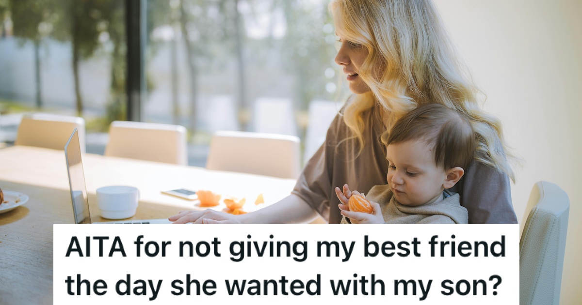 A woman holding her son while using a laptop