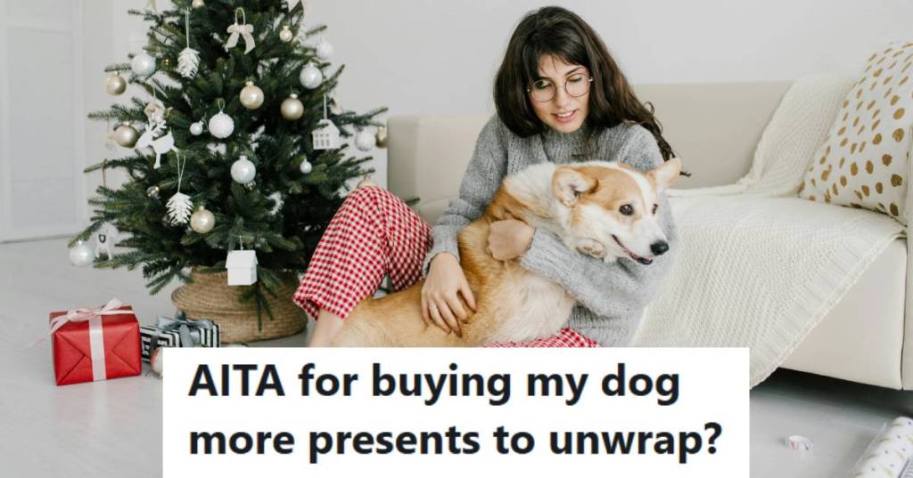 Woman holding her corgi by the Christmas tree so he can unwrap gifts