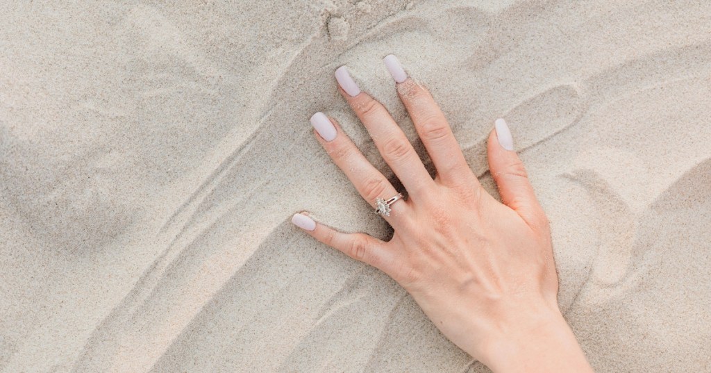 A woman's hand touching sand
