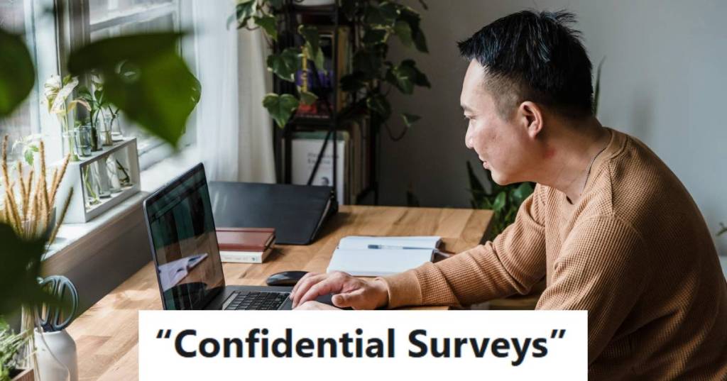 Man sitting on the computer filling out a survey about his job