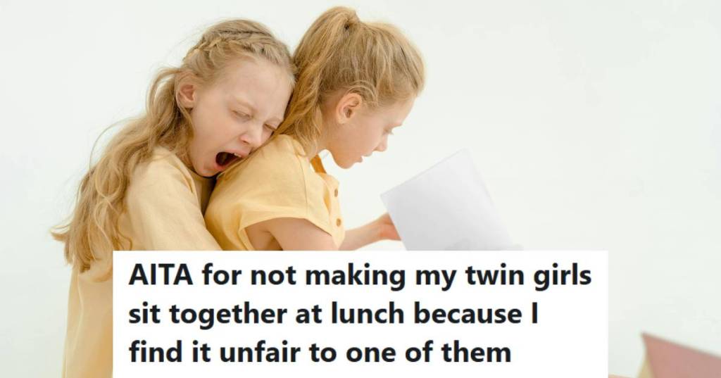 Twin girls sitting on a bed, reading a book to each other