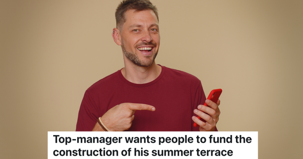 smiling man in red shirt pointing at his cell phone