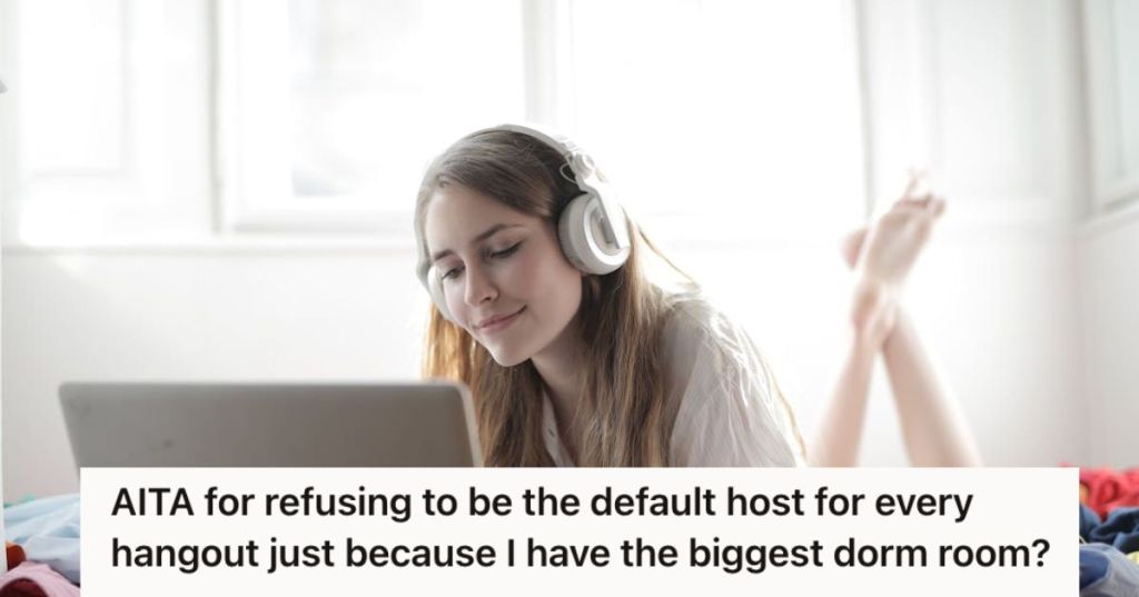 Woman wearing headphones looking at her laptop on bed