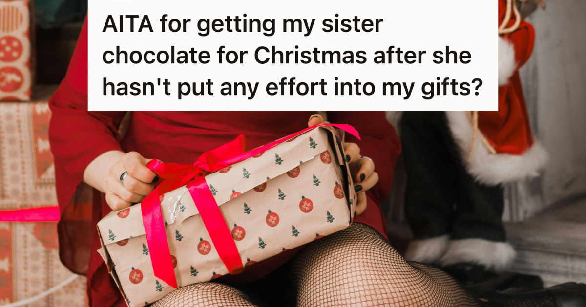 woman holding a christmas gift by the tree