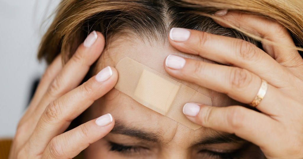 A woman with a band aid on her forehead