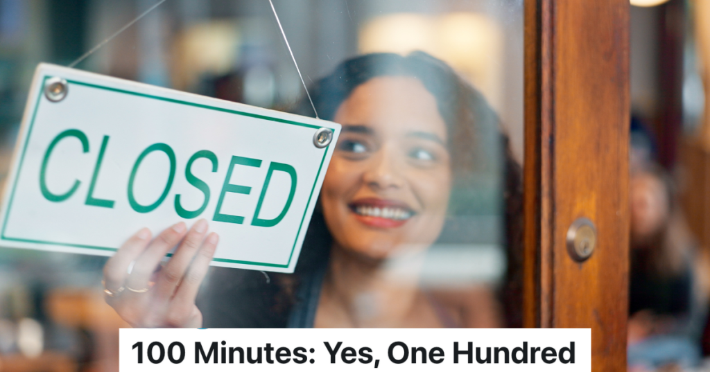 woman putting a closed sign in a store window