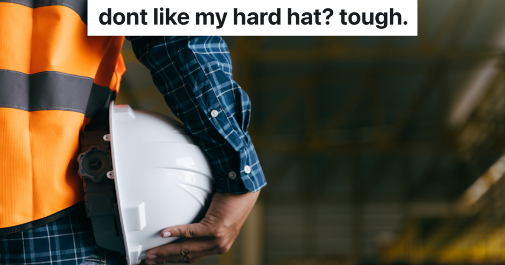 closeup of man in orange vest holding white hardhat under his arm
