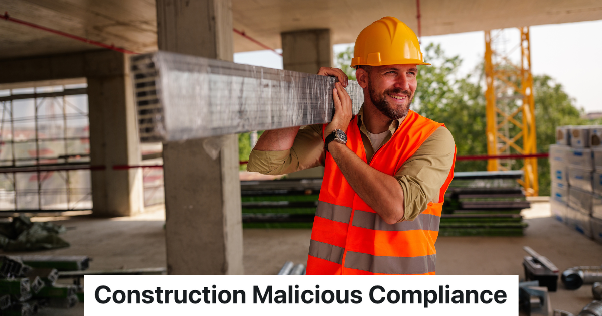 smiling construction worker in hardhat and orange vest holding a metal beam on his shoulder
