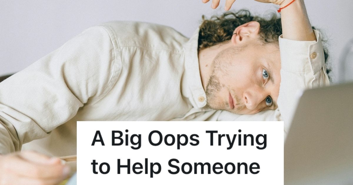 Man with head on table, looking at laptop