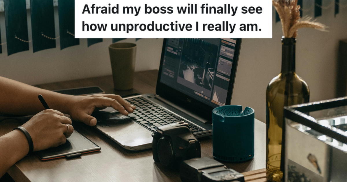 Person's desk with hand on laptop keyboard.