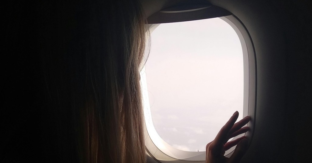 A woman looking out of an airplane window