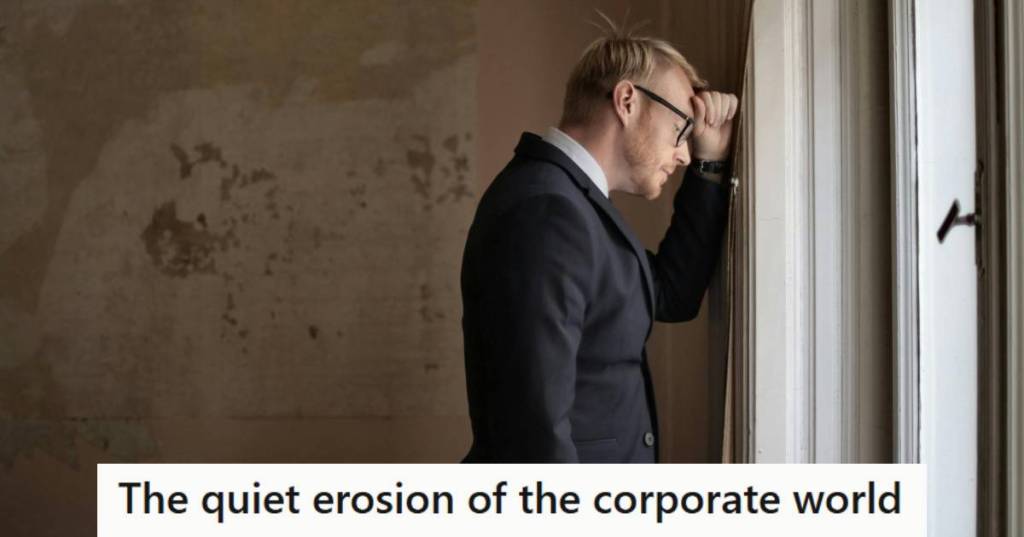 man resting his head on the wall because he's overwhelmed in the corporate world