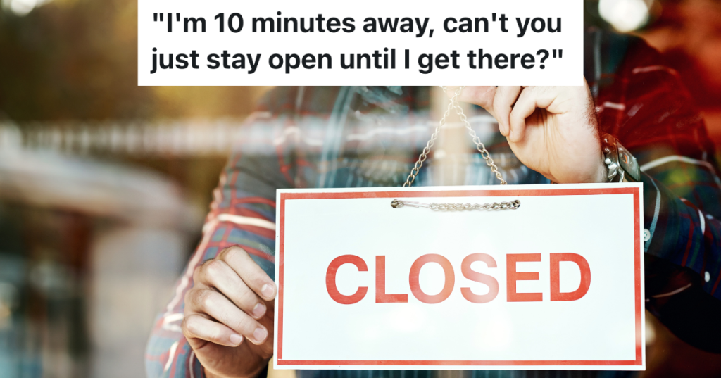 man putting closed sign in store window