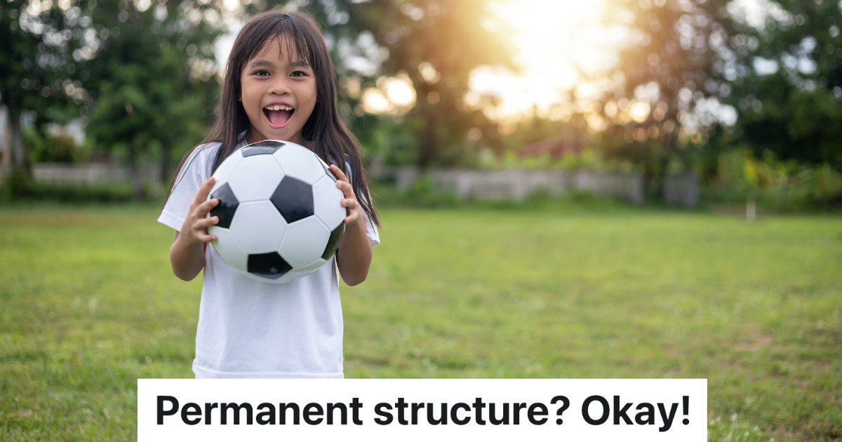smiling little girl holding a soccer ball