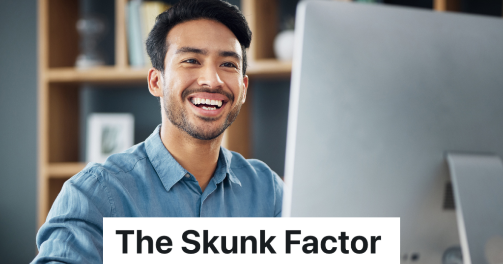 smiling man looking at a computer monitor