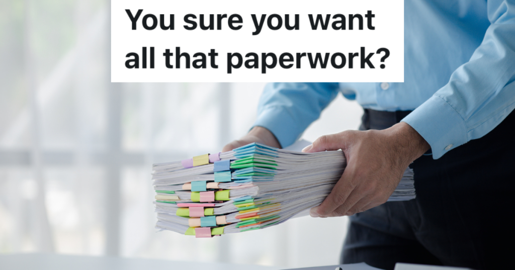 businessman holding a large stack of paperwork