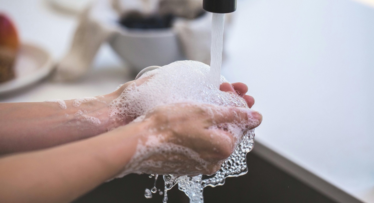 A person washing their hands at the sink