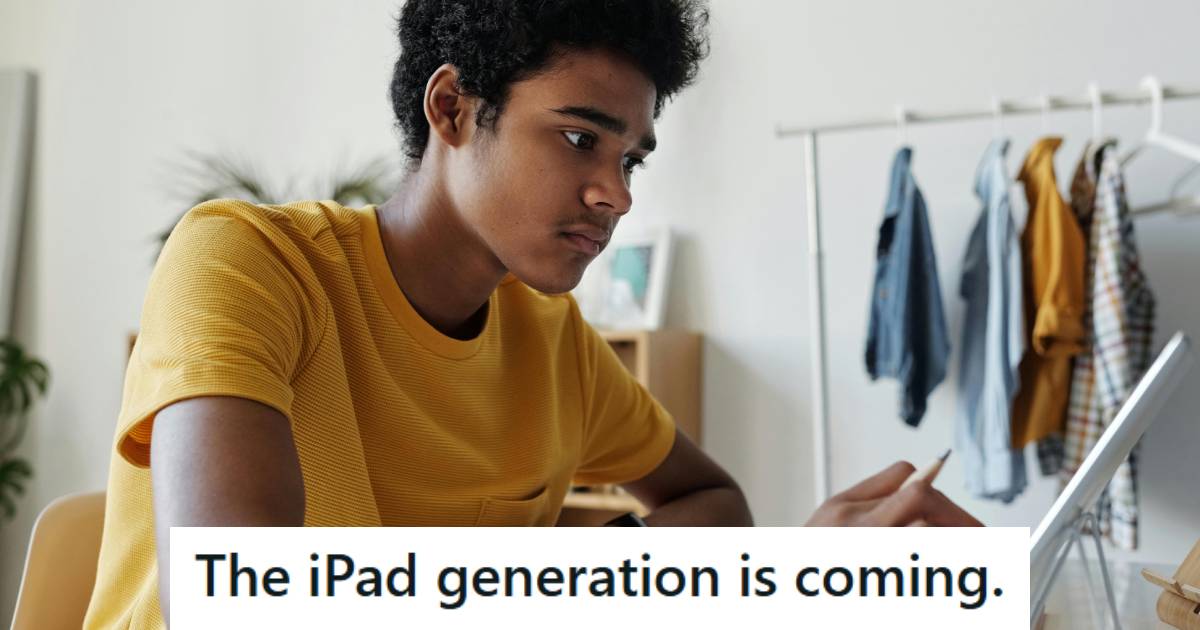 High school kid sitting at his desk, using an iPad