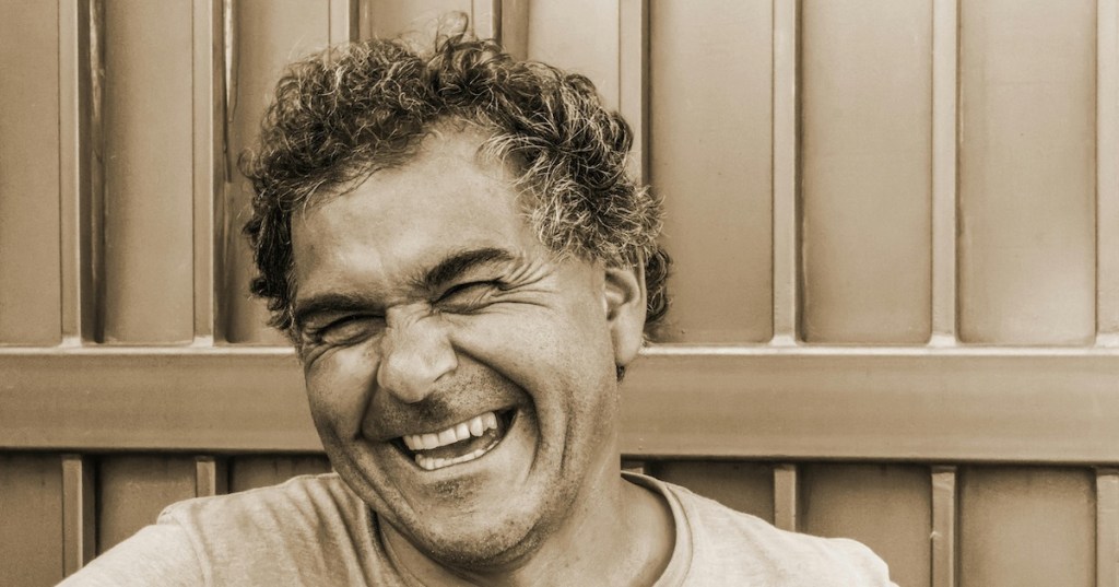 A middle aged man laughing