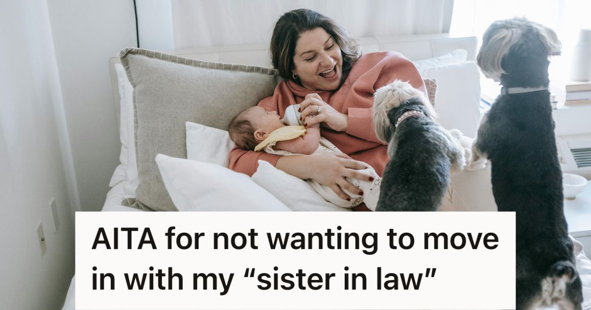 Woman feeding a baby in bed with two dogs