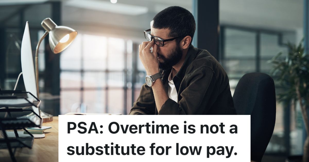 man rubbing his eyes while sitting at a desk