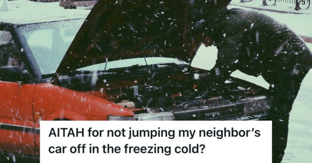 Person fixing a car that won't start while snowing