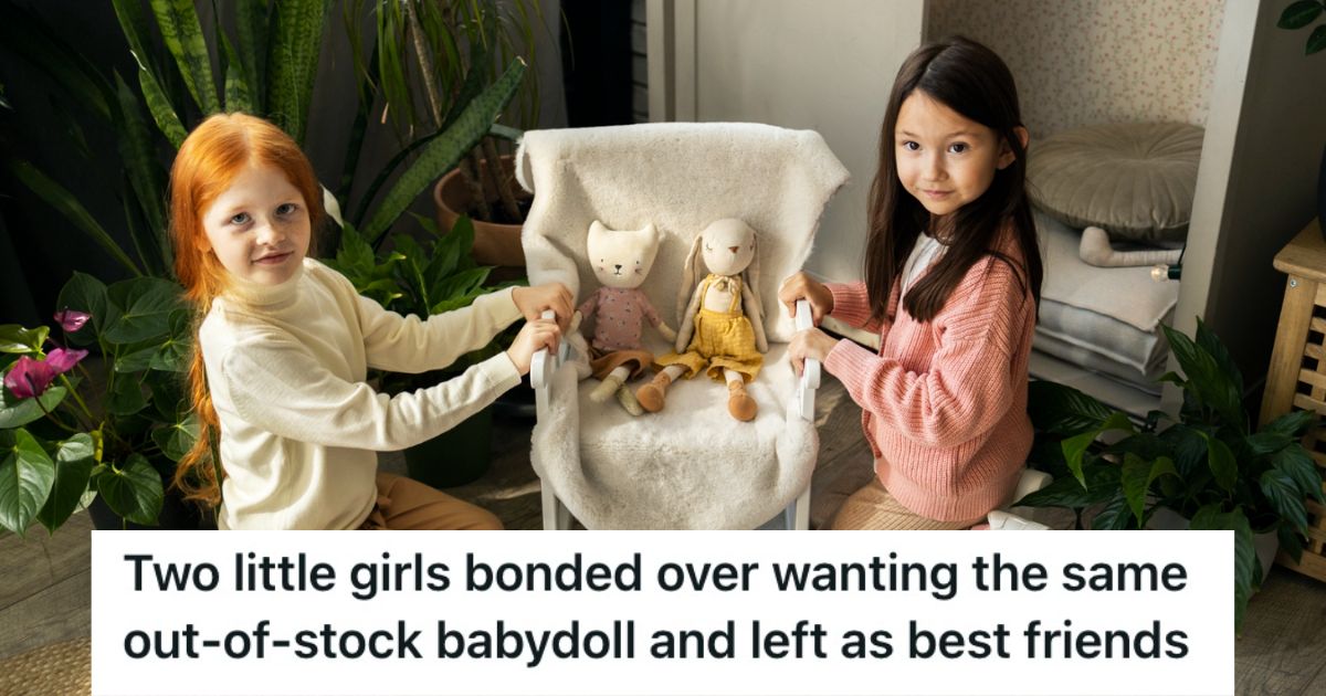 Two girls sitting on the floor and playing with dolls 